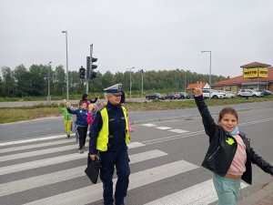 policjantka przeprowadzająca dzieci przez przejście dla pieszych