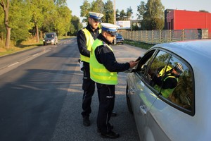 Zdjęcie przedstawia policjantów ruchu drogowego kontrolujących stan trzeźwości kierowcy.