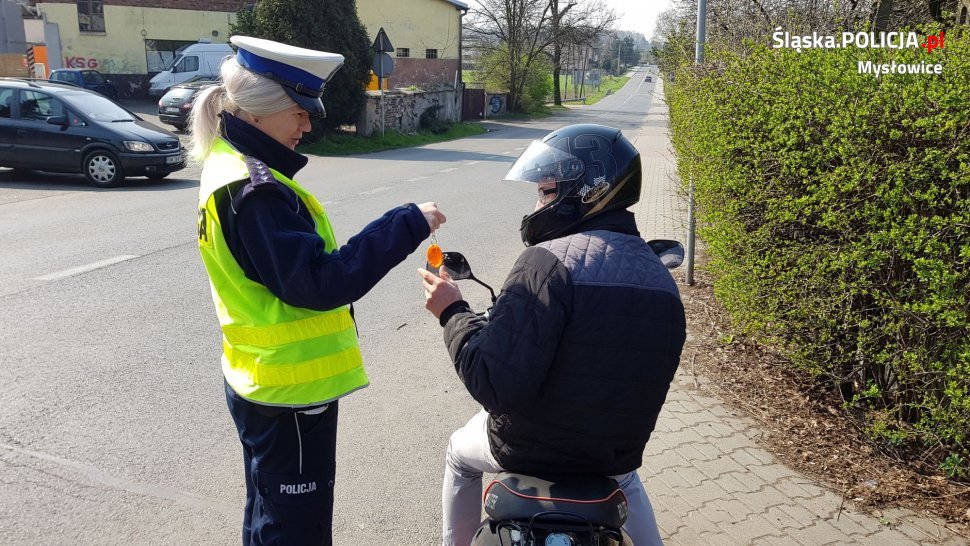 policjantka wręcza odblask kierującemu jednośladem