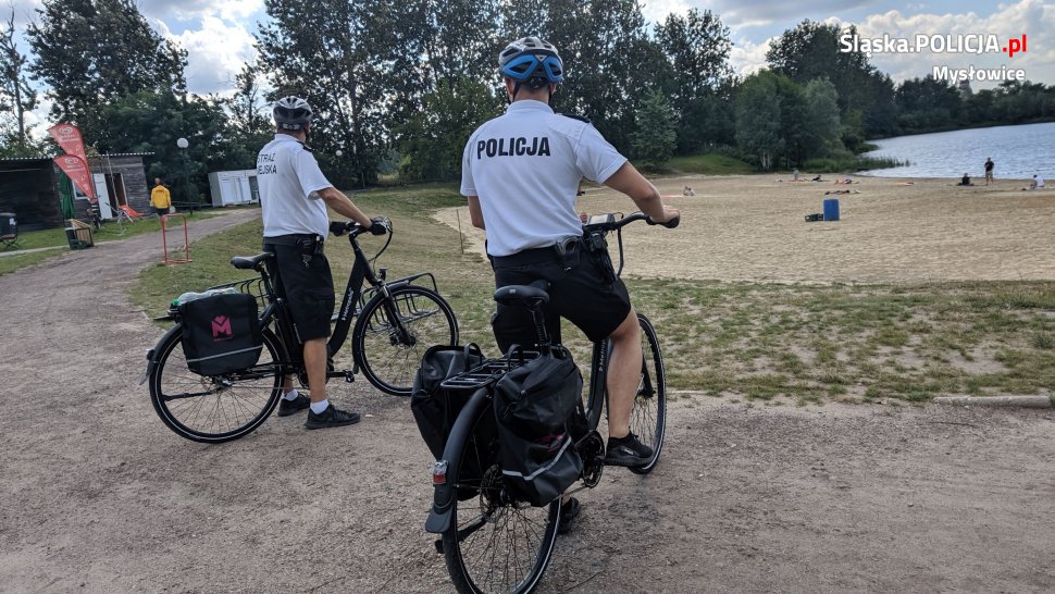 policjant i strażnik miejski na rowerach patrolują rejon kąpieliska Hubertus