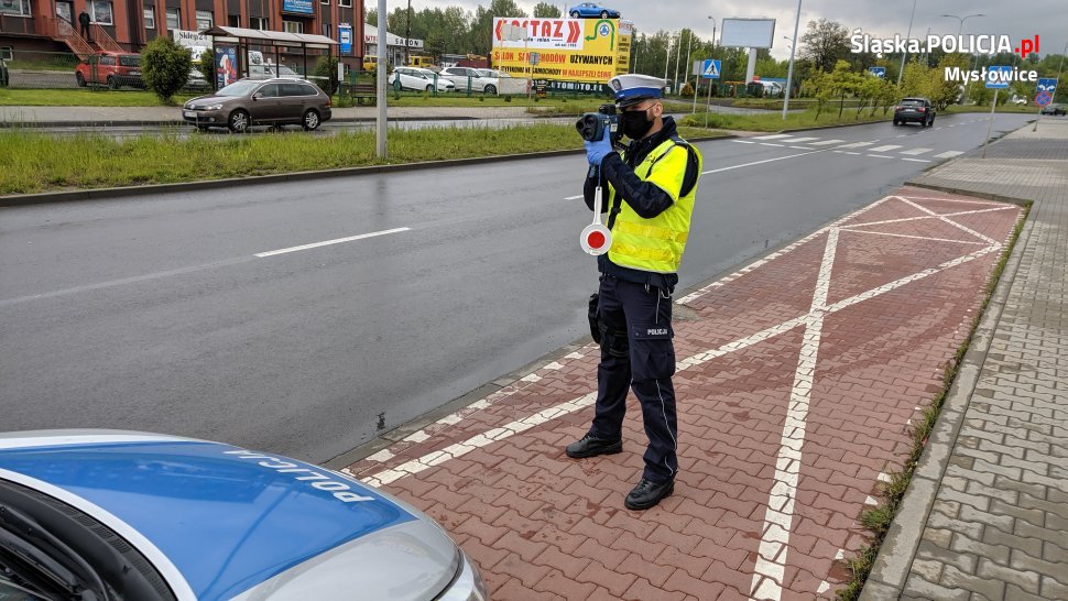 policjant mierzący prędkość laserowym miernikiem prędkości