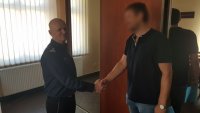 komendant podaje rękę policjantowi i wręcza list gratulacyjny