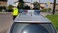 policyjny radiowóz i policjant w rejonie przejścia dla pieszych