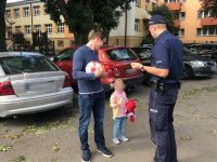 policjant wręcza odblaski pieszym