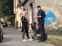 policjant wręcza odblaski pieszym