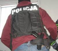 policjant operacyjny z kamizelką z napisem policja