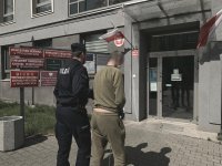 Zdjęcie kolorowy. Policjant i zatrzymany mężczyzna