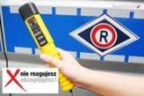 urządzenie alcoblow na tle radiowozu i hasło kampanii &quot;Nie reagujesz - Akceptujesz!&quot;