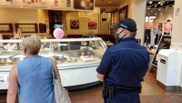 policjant i inspektor sanitarny kontrolują punkt gastronomiczny