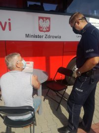 policjant rozmawia z mężczyzną, który chce oddać krew