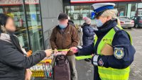 policjantka wręcza elementy odblaskowe podczas akcji Bezpieczny pieszy