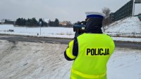 policjant mierzy prędkość kierujących w rejonie przejścia dla pieszych