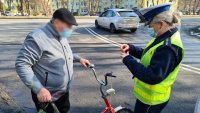 policjantka rozmawia z rowerzystami o ich bezpieczeństwie na drodze i wręcza elementy odblaskowe dla poprawy ich widoczności i bezpieczeństwa