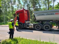 policjanci kontrolują samochód ciężarowy z naczepą