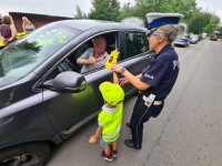 chłopczyk i policjantka wręczają kierowcy laurkę z okazji Dnia Ojca