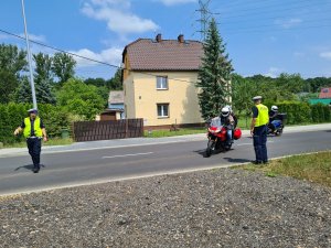 Policjanci ruchu drogowego zatrzymują do kontroli kierujących motocyklami.