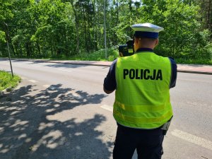 policjant z urządzeniem TruCam mierzy prędkość pojazdów