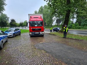 policjanci ruchu drogowego zatrzymują do kontroli samochód ciężarowy