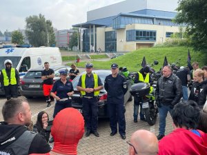 policjanci w trakcie pogadanki w uczestnikami zlotu na parkingu przed halą MOSIR