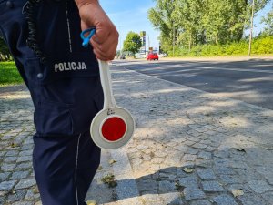 Policjant trzymający w ręce tarcze do zatrzymywania pojazdów