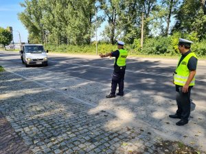 policjant ruchu drogowego i funkcjonariusz ITD zatrzymują do kontroli samochód dostawczy