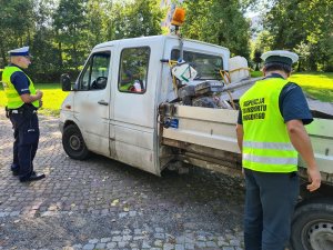 policjant ruchu drogowego i funkcjonariusz ITD podczas kontroli kierowcy samochodu dostawczego