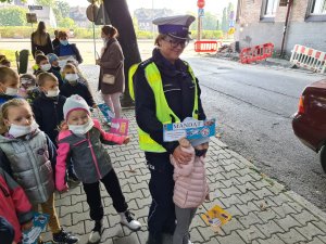 policjantka ruchu drogowego z dziewczynką trzymającą w ręku przygotowany mandat