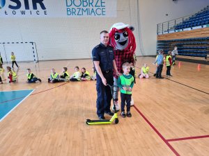 zdjęcie policjanta, przedszkolaka i maskotki MOKu Mysłowice