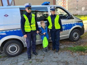 zdjęcia policjantów ruchu drogowego i chłopca na tle radiowozu