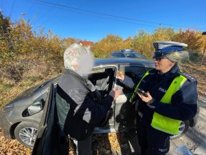 policjantka wręcza kierującemu element odblaskowy