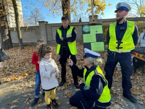 policja i straż miejska wręcza dzieciom elementy odblaskowe