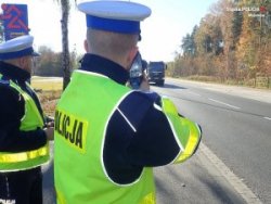 umundurowany policjant dokonuje pomiaru prędkości nadjeżdżającemu pojazdowi