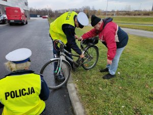 policjanci kontrolują rower w obecności własciciela