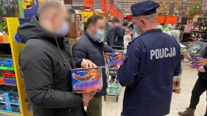 policjanci rozdający ulotki klientom przy stoisku z fajerwerkami