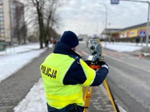 policjant dokonujący pomiarów na miejscu zdarzenia