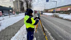 policjant dokonujący pomiarów na miejscu zdarzenia