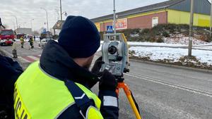 policjant dokonujący pomiarów na miejscu zdarzenia