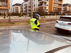 policjanci w trakcie kontroli drogowej przy zatrzymanym pojeździe