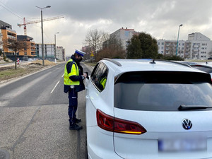 policjanci w trakcie kontroli drogowej przy zatrzymanym pojeździe