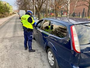 policjanci w trakcie kontroli drogowej przy zatrzymanym pojeździe