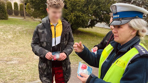 policjantka rozdająca rowerowe lampki led