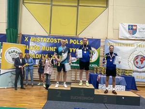 zdjęcie przedstawia policjantów na podium w strojach sportowych