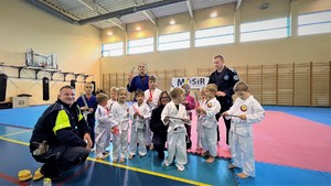 zdjęcie grupowe policjantów oraz dzieci w trakcie treningu ju jitsu