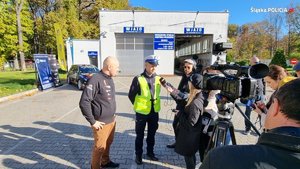 zdjęcie przedstawia policjanta udzielającego wywiadu dla telewizji