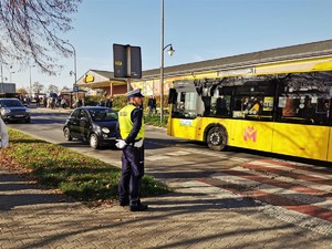 zdjęcie przedstawia policjanta stojącego przy przejściu dla pieszych