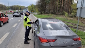 zdjęcie przedstawia policjanta w trakcie kontroli drogowej