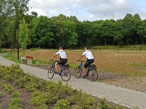 zdjęcie przedstawia policjantów na rowerach w trakcie patrolowania parku