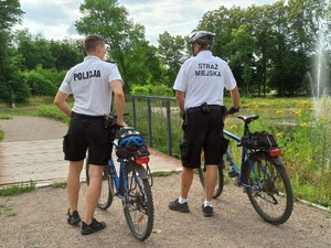 zdjęcie przedstawia policjantów na rowerach w trakcie patrolowania parku