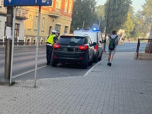 zdjęcie przedstawia policjantów w trakcie kontroli drogowej