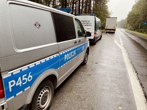 zdjęcie przedstawia policjanta i funkcjonariusza inspekcji transportu drogowego przy pojazdach